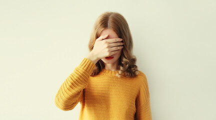 Upset sad young woman keeps hand palm on face, regrets or sorrow gesture on head