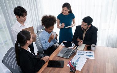 Multiracial analyst team use BI dashboard data to analyze financial report on meeting table. Group...