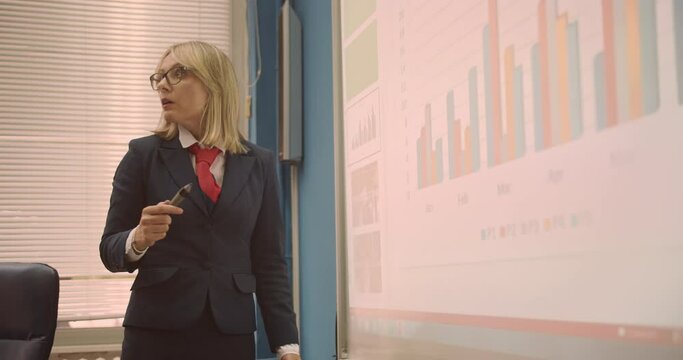 Professor writing notes on the smart board while giving lectures to students at the university class