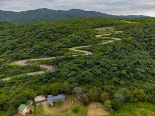 vista aerea desde el dron de un camino zigzagueante con vegetacion alrededor, La Merced, Catamarca, Argentina