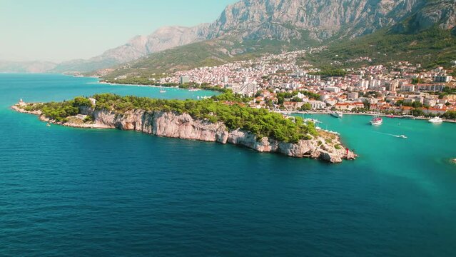Scenic Overlook of a Coastal City Makarska with Crystal Sea Waters in Croatia. Aerial view of mountain landscape and town in summertime.