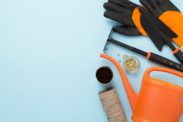 Orange gardening tools on color background, top view