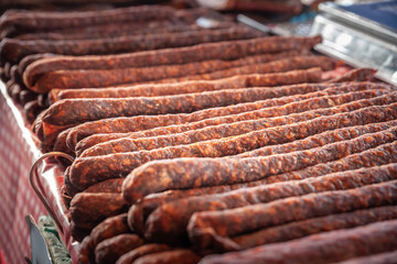 Selective blur on cajna kobasica sausages spiked for sale on a stand of a serbian market. Cajna kobasica, or tea sausage, is a traditional serbian sausage made of smoked cured pork.