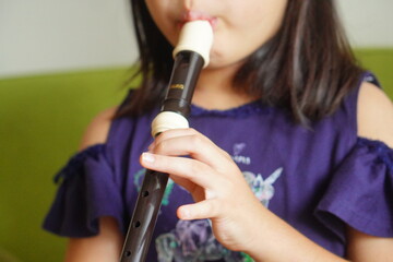 リコーダーを吹いている小学4年生の女の子。