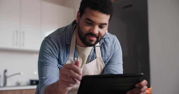 Man, tablet and research in kitchen for cooking recipe, ingredients or online tutorial at home. Young male person or happy chef with technology for virtual class, course or reading blog at house