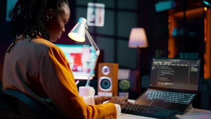 University student and coding enthusiast delves into cloud computing, expanding her knowledge beyond online class lessons. African american girl using programming language. Camera B.