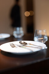 Simple dining table, table setting, glasses, metal cutlery, white ceramic plates, platters, simple style restaurant decoration, green management, environmentally friendly enterprise