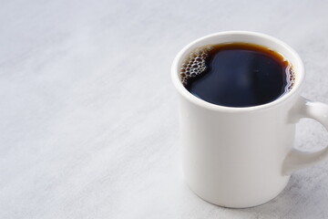 淹れたてのコーヒーが入った白いマグカップ
