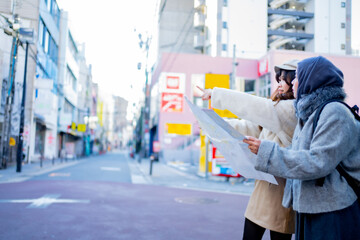 Travel japan,woman girl tourist Two Asian friends but different religions, one of whom is a Muslim girl.Looking at the tour map View information on traveling in Japan.She is traveling in the city area
