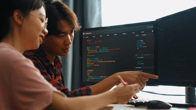 Slow motion back end software developer engineer for computer programming working together on debugging writing computing code, solving complex algorithms display on monitor in office. Burgeoning