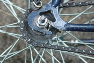 part of a bicycle wheel with gray spokes, a hub and a brake on a blue bicycle frame lies on the...