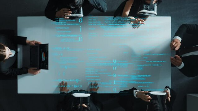 Top view of diverse data analysts wearing VR headsets stands coding program holographic while using hand gestures to manipulate programing engineering prompt from the manager laptop. Directorate.