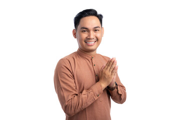 Happy Asian Muslim man gesturing Eid Mubarak greeting isolated on white background. Ramadan and Eid Fitr celebration concept