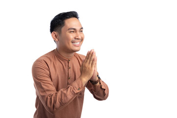 Happy Asian Muslim man gesturing Eid Mubarak greeting isolated on white background. Ramadan and Eid Fitr celebration concept