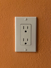 Electrical outlet on orange wall