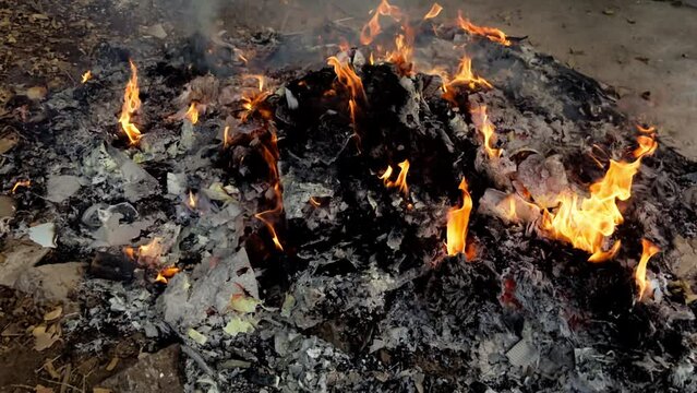 Burning garbage heap with flames and smoke environmental pollution concept roadside fire