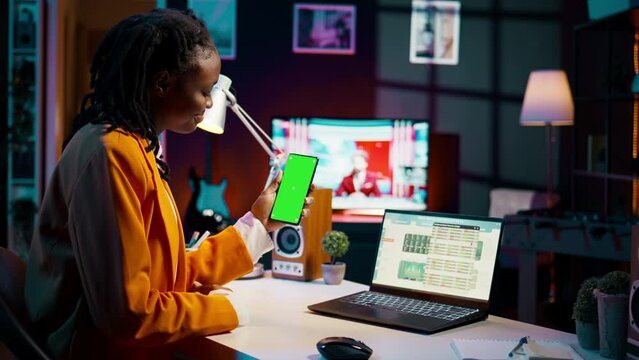 Young woman working with financial spreadsheet and greenscreen, learning about money management and cost calculations for economy class lesson. Student looks at isolated mockup. Camera B.