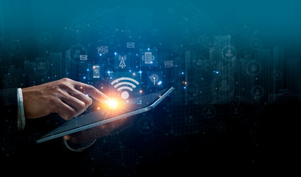Wireless systems and internet of things connection technology concept. Businessman touching on tablet with virtual screen of free WiFi network signal technology internet connection communication. - Powered by Adobe