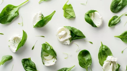Tuinposter Fresh spinach leaves paired with soft mozzarella cheese pieces artfully arranged on a clean white surface, symbolizing healthy eating. © TPS Studio