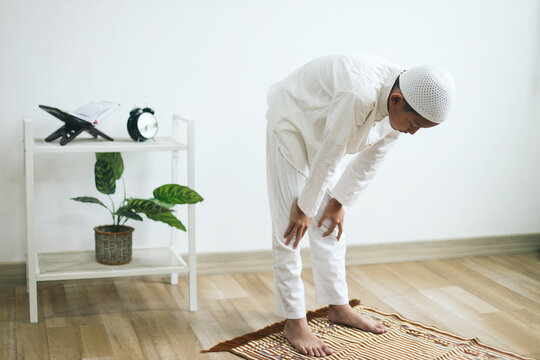 Muslim boy doing salat with ruku gesture on the praying mat