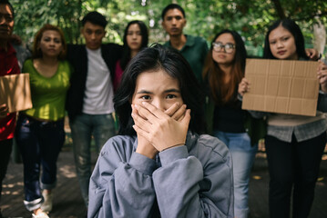 Group of people protesting for freedom of speech while holding signs and covering mouth