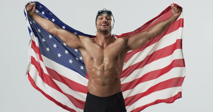 Athletic biracial athlete swimmer celebrates victory wrapped in the American flag