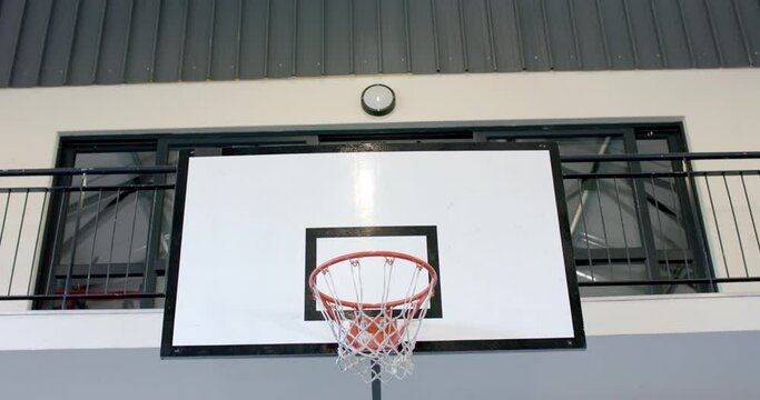 A basketball hoop is mounted on an outdoor wall, with copy space