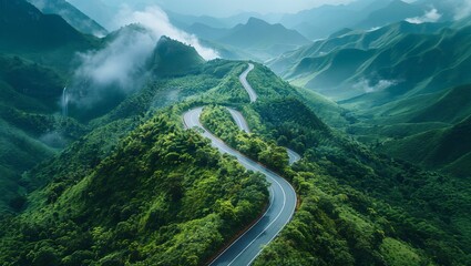 Aerial shot of a curved road on a green mountain in the rainy season