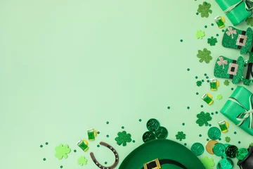  Saint Patrick Day green background with hat, shamrock clover and accessories with gifts top view. Festive greeting card. © juliasudnitskaya