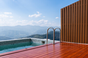 Infinity pool exterior design on the terrace of rooftop with a stunning mountain panoramic view, sky and white clouds offering a serene and luxurious escape at a high end resort