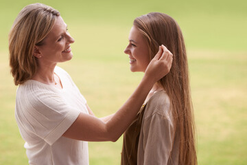 Happy, mother and daughter touching hair for love, care and proud family for support. Woman,...