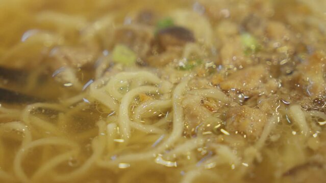Chopsticks inside asian Bakmi noodle soup. Close up