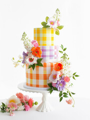 Pretty Trendy Gingham colorful floral wedding cake with 3 tiers in for Spring Summer party, bold colorful yellow purple orange colors on white background, cake decorating design modern happy mock up