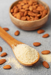 Fresh almond flour in a  wooden spoon and almonds
