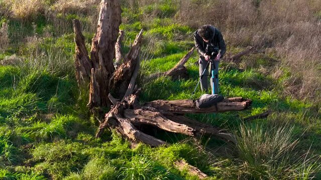 Outdoor Photographer With Camera And Tripod Next To Dead Tree Wood On Field. drone shot