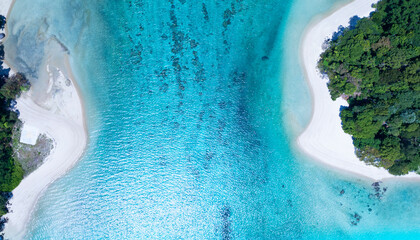 Top view of white sand beach tropical with seashore as the island in a coral reef ,blue and turquoise sea Amazing nature landscape with blue lagoon.