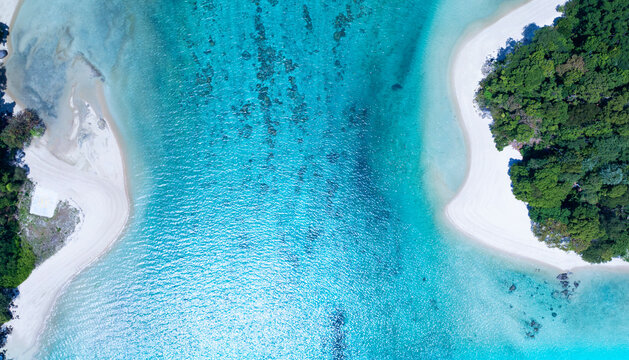 Top view of white sand beach tropical with seashore as the island in a coral reef ,blue and turquoise sea Amazing nature landscape with blue lagoon.