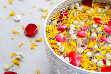 Water with jasmine flower, marigold petal and rose petal in silver bowl. Thai tradition, Songkran Festival 