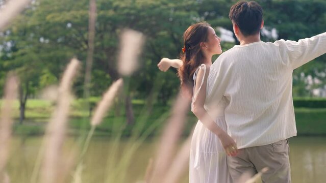 Young adult asia people happy lover flirt at public nature park falling in love desire kiss hug beloved care trust. Sweet asian lovers tender face to face man woman smile relax warm time date day.