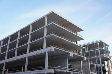 Close up of grey block empty new building at Construction process towards blue sky. Tallinn, Estonia, Europe. February 2024.