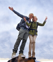 Couple, hiking and excited on mountain top for travel, success and achievement with peace sign on...