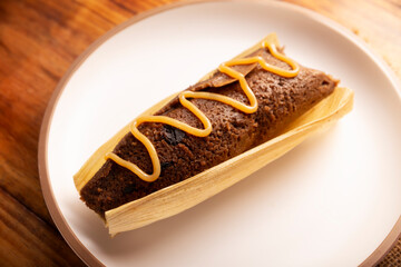 Chocolate Tamale. hispanic dish typical of Mexico and some Latin American countries. Corn dough wrapped in corn leaves. The tamales are steamed. Usually accompanied with atole, hot chocolate or coffee