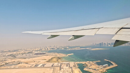 An aerial view of an airport with a plane flying over it