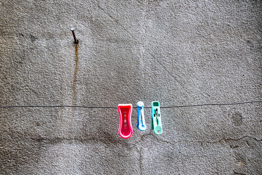 Three.  Three pegs and a nail on a concrete wall.