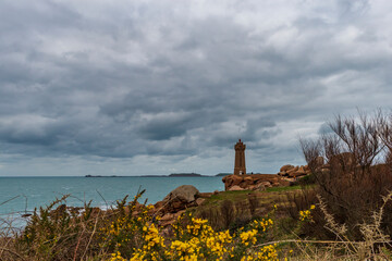 View of the Ploumanac'h lighthouse, under a threatening sky, located on the famous pink granite coast in Brittany.
