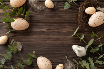 Trendy eco Easter concept. Top view of pale eggs, slender quail feathers, a nest, a stoneware...