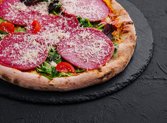 Delicious pizza with salami, arugula and tomatoes