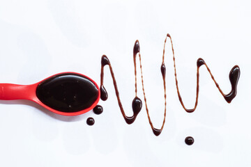 Chocolate spoon splash on white background.