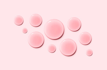 round drops of serum gel texture cosmetic products on a light pink background top view