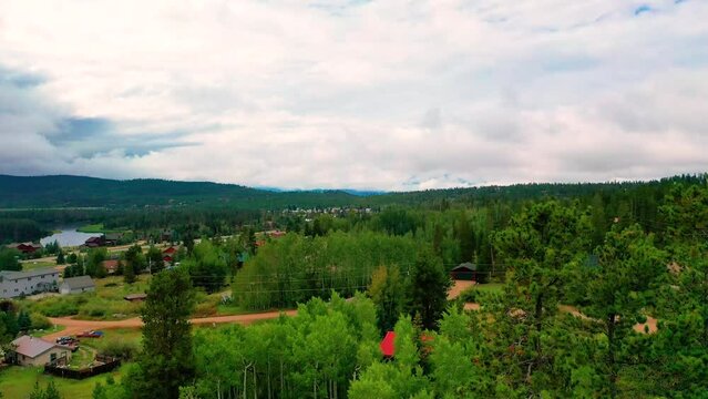 Aerial Drone Reveal of the Town of Grand Lake, Colorado with Peaceful Mountain Vacation Homes Surrounded by Pine Tree Forests on Couldy Summer Day